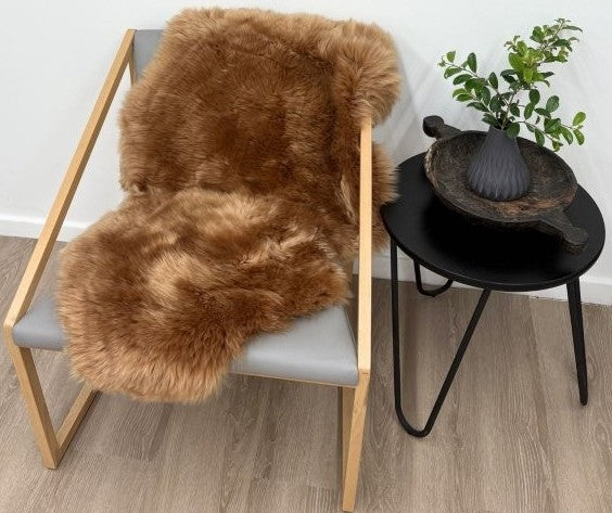 Butterscotch Merino sheepskin rug styled over armchair in living space