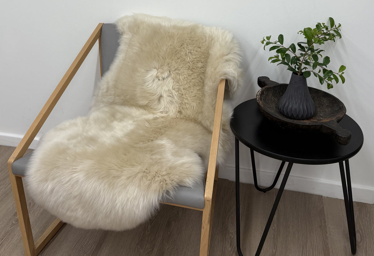 Fawn Merino sheepskin rug styled over armchair in living space