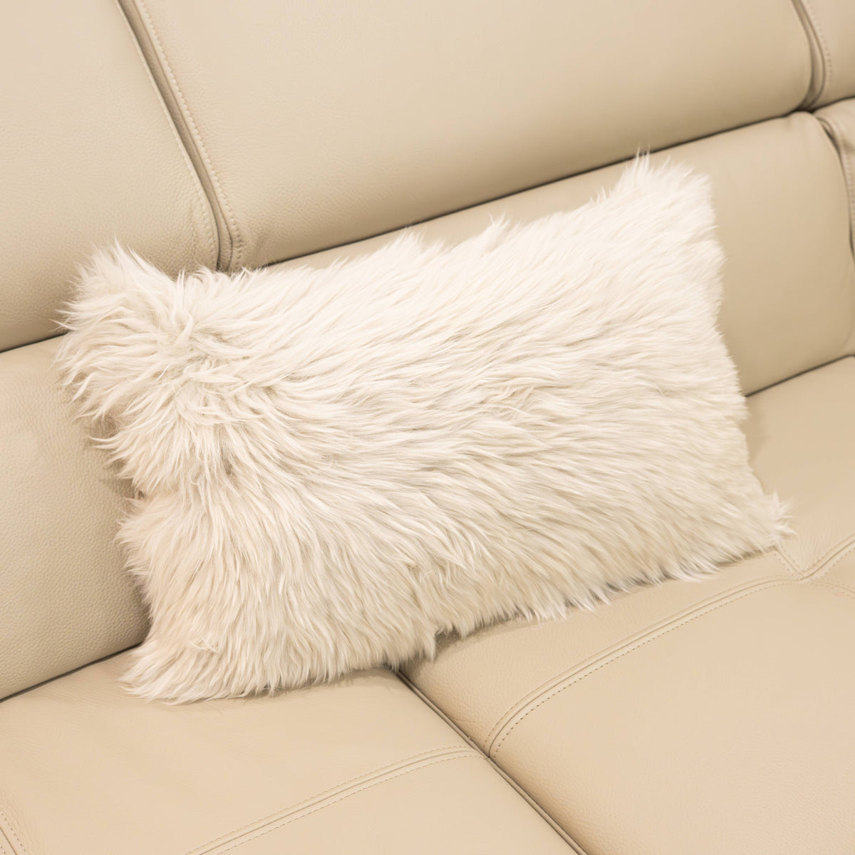 New Zealand sheepskin lumbar cushion in linen with soft long wool texture displayed on a beige sofa