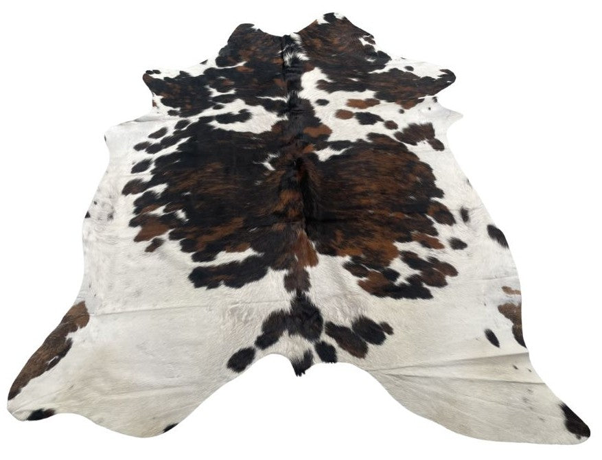 Tri colour cowhide rug example showing natural tonal variation and markings on a white background