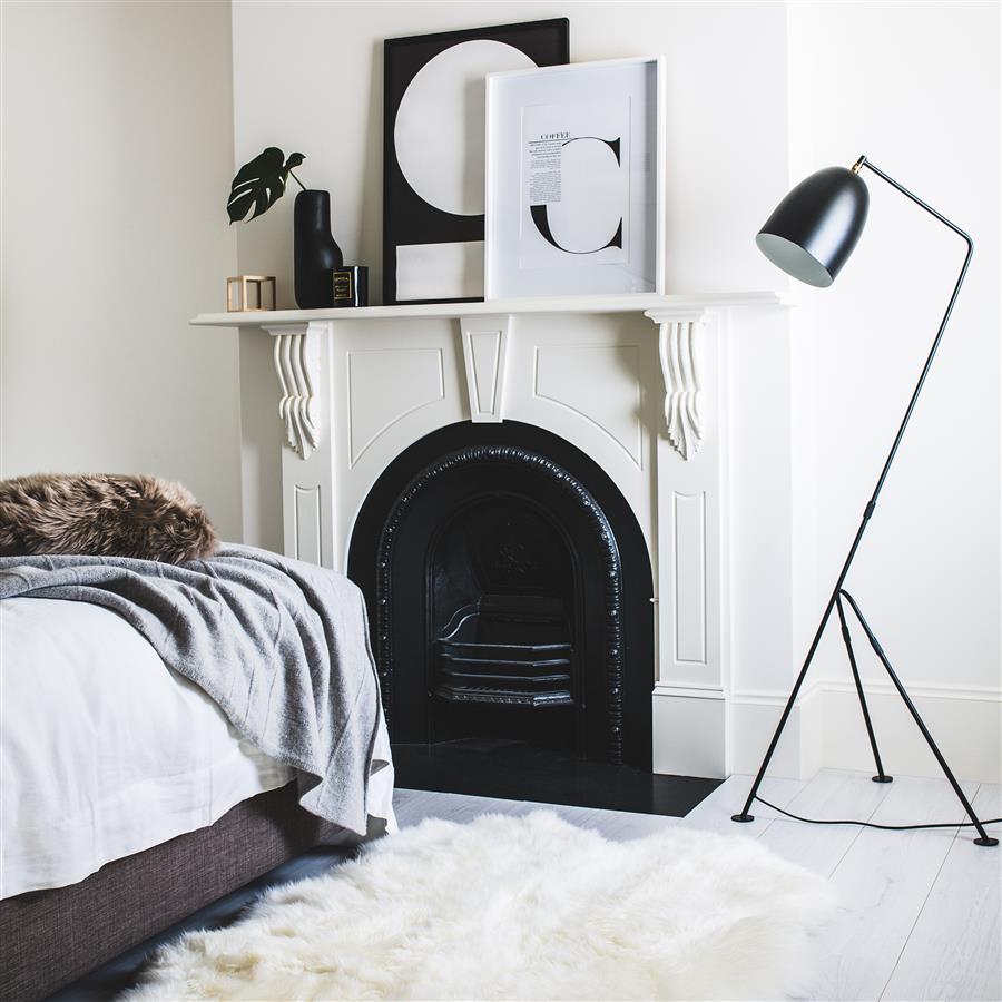 White merino sheepskin rug styled in a modern bedroom with fireplace