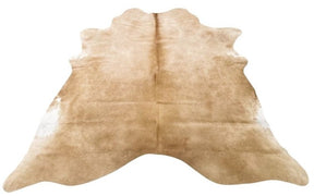 Beige cowhide rug example showing natural shape, soft tonal variation and smooth hair on a white background