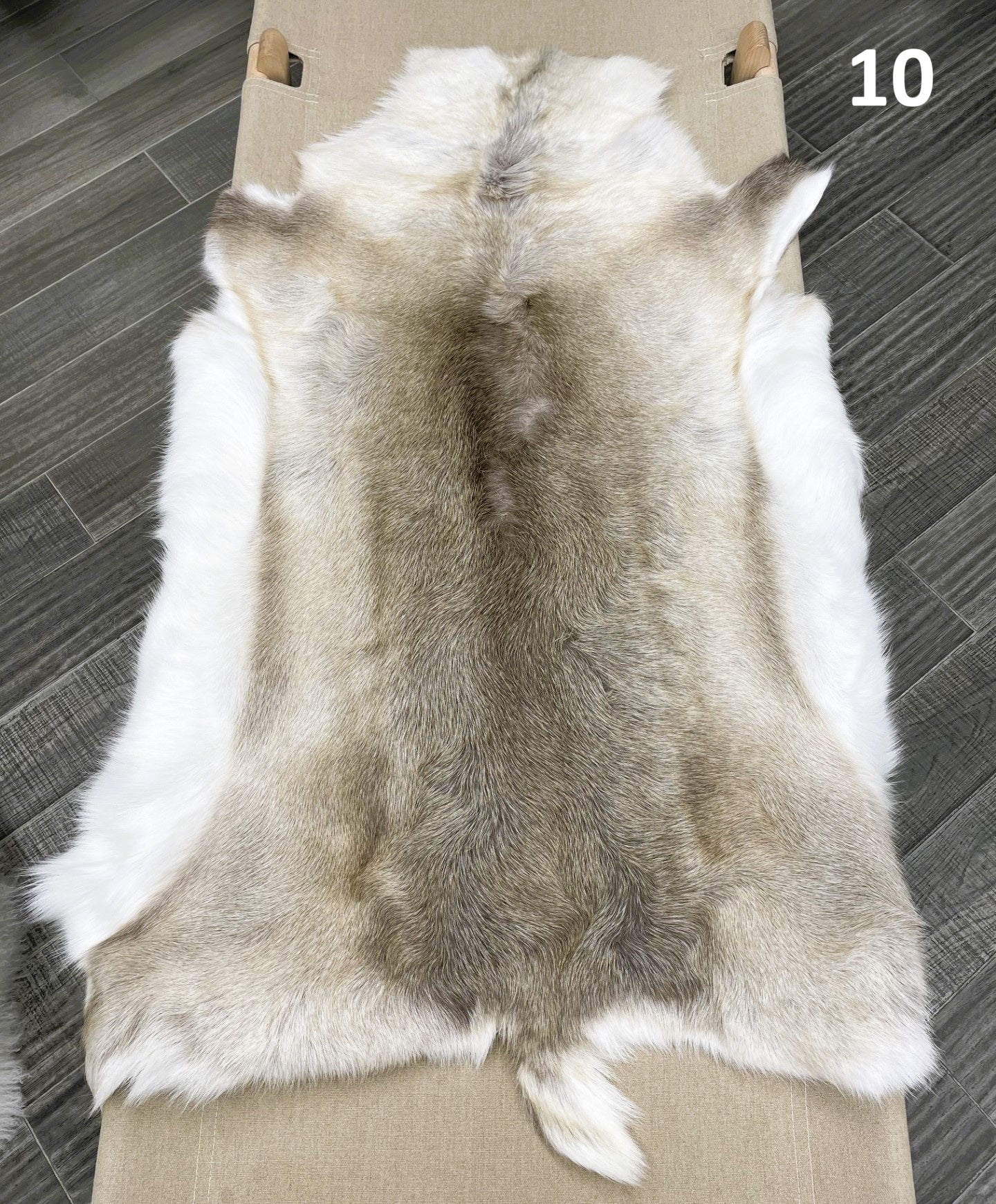 Beige reindeer hide throw numbered 10 showing natural markings and shape