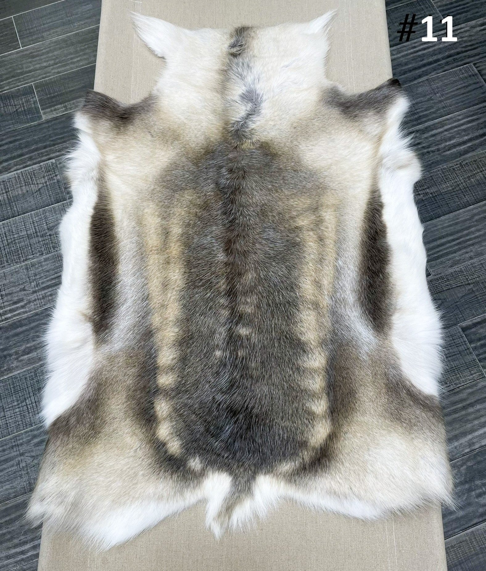 Beige reindeer hide throw numbered 11 showing natural markings and shape