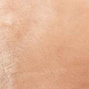 Close-up of blush sheepskin baby rug showing fine wool fibres and gentle tonal variation