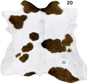 Natural brown and white calf hide rug shown individually on a white background
