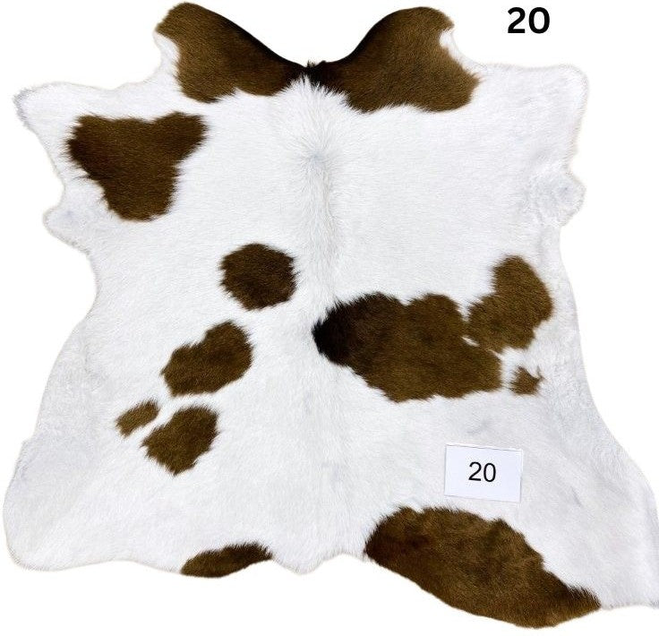 Natural brown and white calf hide rug shown individually on a white background