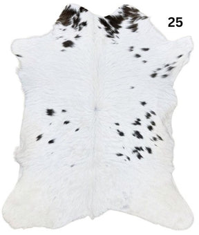 Natural brown and white calf hide rug shown individually on a white background
