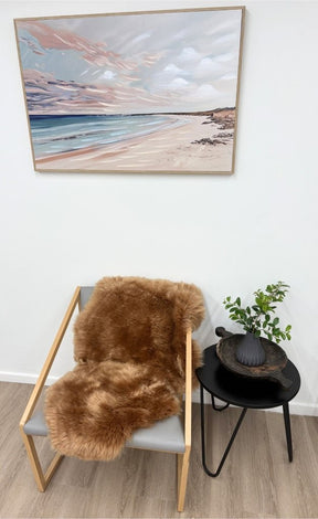 Butterscotch Merino sheepskin rug styled over armchair in living space