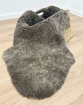 Chocolate fleck shearling rug in its natural shape with soft, tightly curled wool and rich flecked tones.