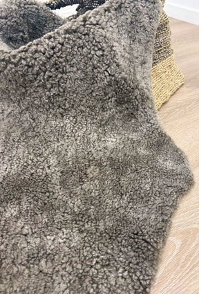 Detailed view of genuine chocolate fleck shearling with soft curly wool and rich flecked tones.