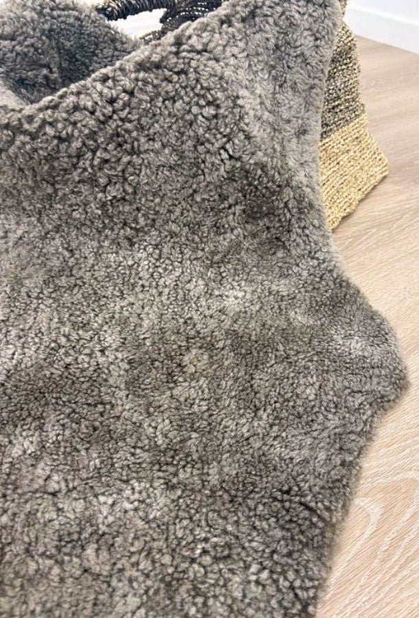Detailed view of genuine chocolate fleck shearling with soft curly wool and rich flecked tones.