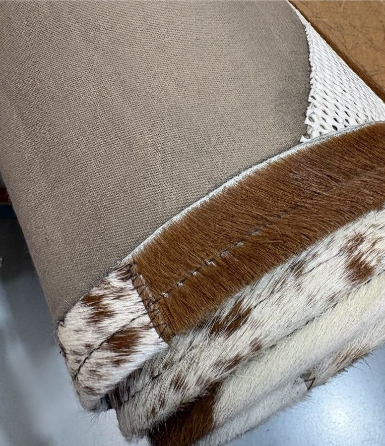Close up of cowhide patchwork rug backing showing padded layer and non slip underlay