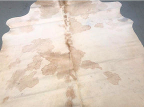 Close-up detail of beige and white cowhide rug showing natural markings and hair texture