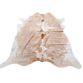Example of a beige and white cowhide rug with natural variation shown on a white background