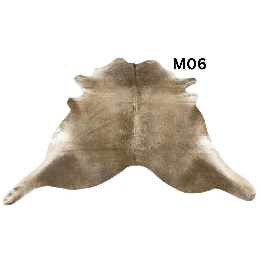 Mocha latte cowhide rug with natural markings shown on a light background