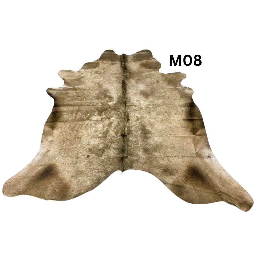 Mocha latte cowhide rug with natural markings shown on a light background