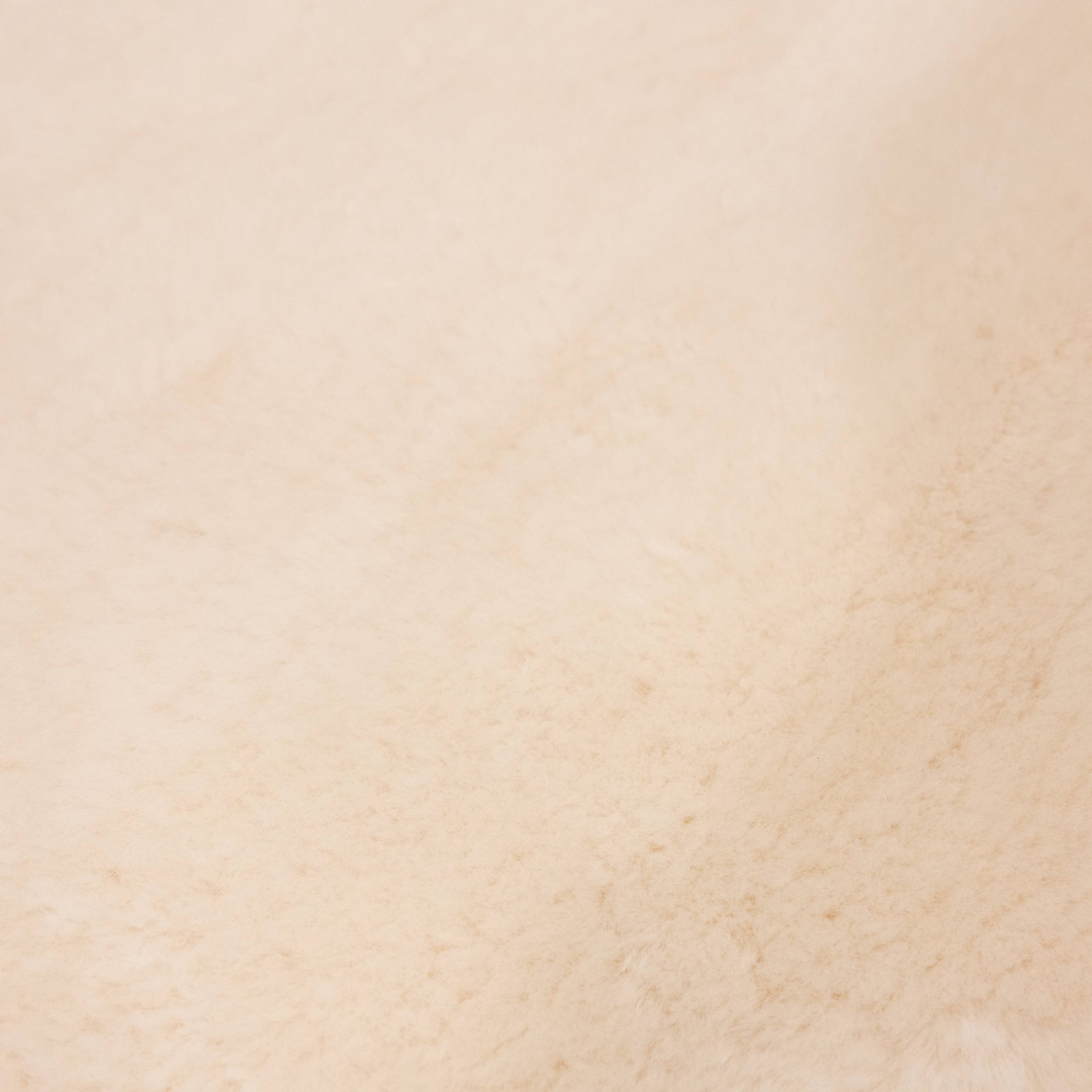 Close-up of dusk sheepskin baby rug showing fine wool fibres and warm tonal variation