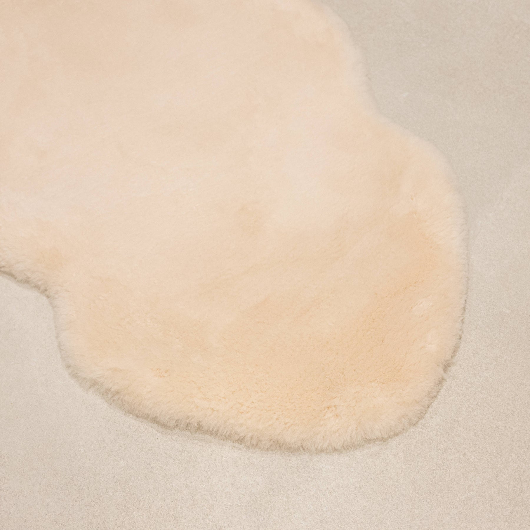 Dusk sheepskin baby rug laid flat showing natural shape and dense wool texture