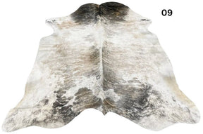Exotic brindle cowhide rug number 09 featuring light and dark natural variation with speckled markings on a white background