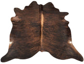 Exotic brindle cowhide rug example showing rich dark tones, central spine detail and natural variation on a white background