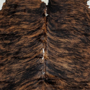 Close-up view of the natural spine and hair direction of a large exotic brindle cowhide rug with brown and tan markings