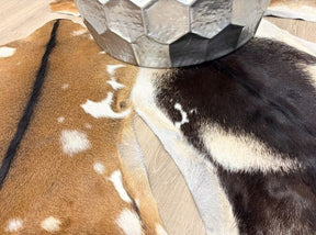 Natural goatskin hide rugs styled together showing varied markings and colour tones