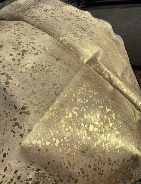 Close-up of gold metallic cowhide rug showing speckled finish on natural hair-on-hide leather