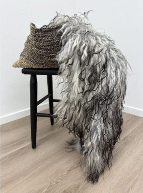 Greenlandic sheepskin rug with long crinkled wool draped over a chair showing natural texture and flowing length