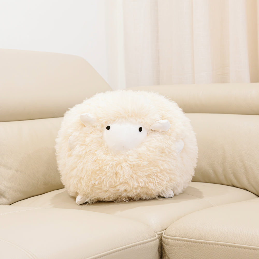 Harold small sheepskin toy made from natural cream sheepskin styled on a sofa