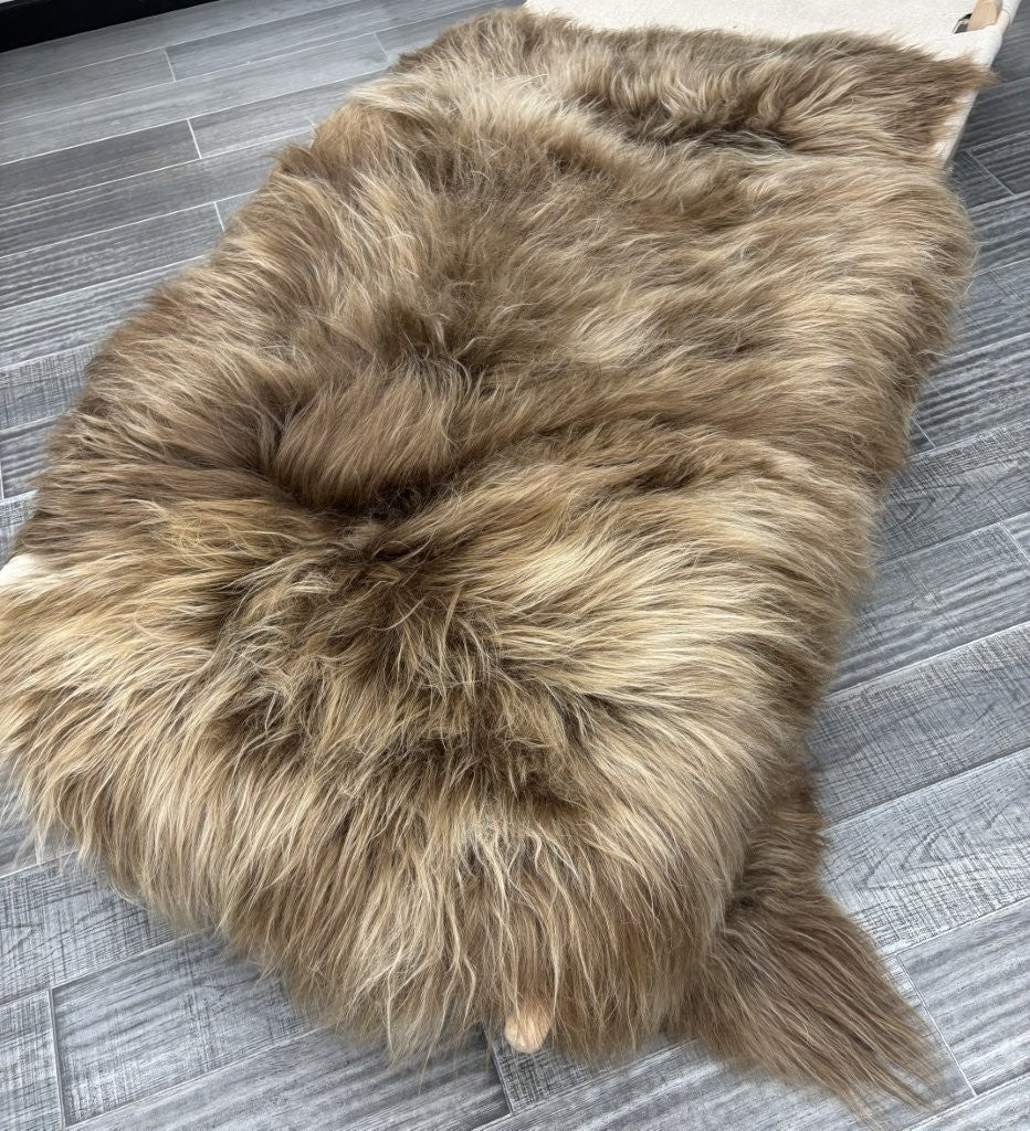 Triple dyed copper caramel Icelandic sheepskin floor rug with long wool fibres styled on a grey tiled floor
