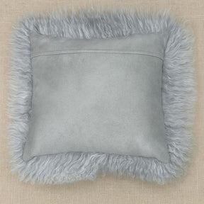 Light grey Mongolian sheepskin cushion photographed flat, showing long hair trim and cotton velour backing on a neutral background