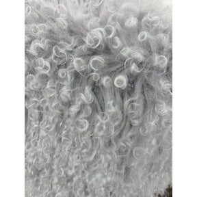 Close-up detail of light grey Mongolian sheepskin cushion showing soft, curly long hair texture