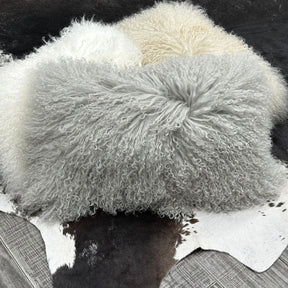 Light grey Mongolian sheepskin lumbar cushions showing long, naturally curly hair and tonal variation