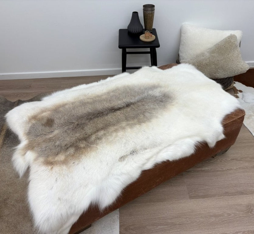 Light reindeer hide throw styled over a bench showing natural hair texture and tonal variation