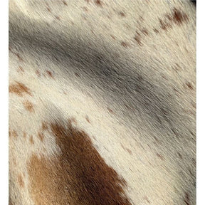Close-up detail of a light speckled longhorn cowhide rug showing smooth natural hair texture and soft tonal variation