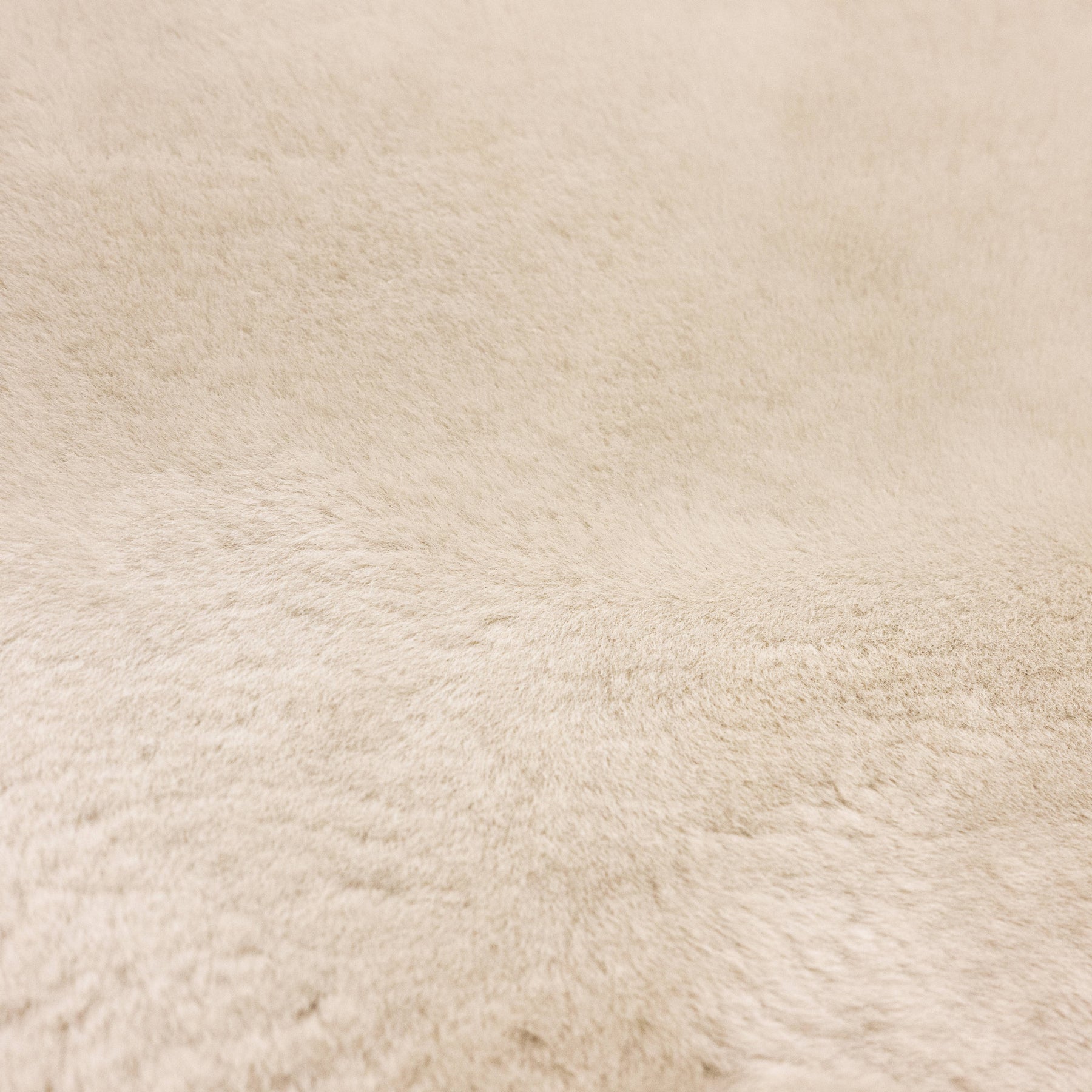 Close-up of linen sheepskin baby rug showing dense wool pile and natural fibre texture