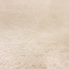 Close-up of linen sheepskin baby rug showing dense wool pile and natural fibre texture
