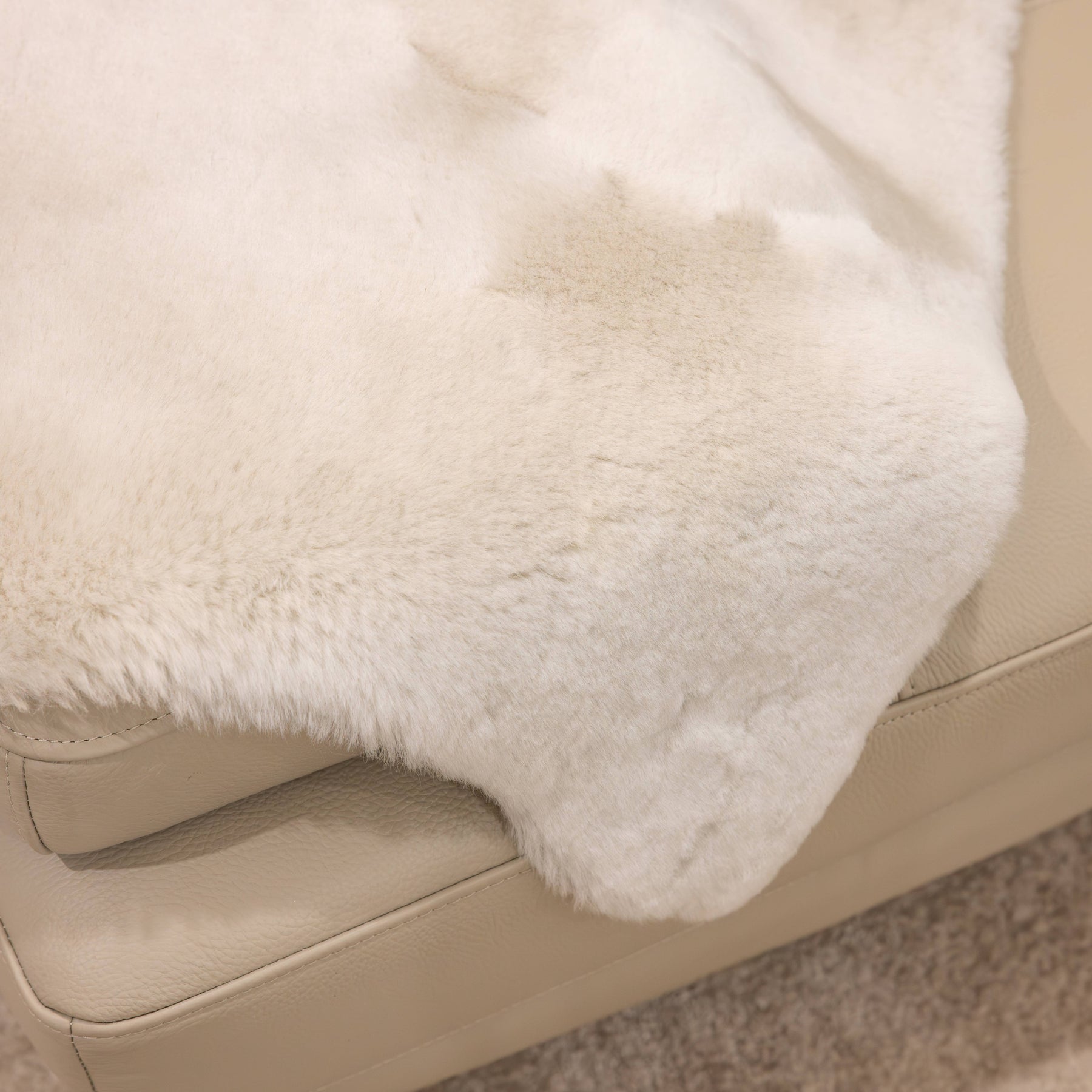 Linen sheepskin baby rug draped over seating showing soft wool texture and natural variation