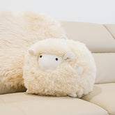 Marty sheepskin toy made from natural cream sheepskin styled on a sofa