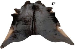 Natural black cowhide rug number 17 with subtle tonal variation and natural markings on a white background
