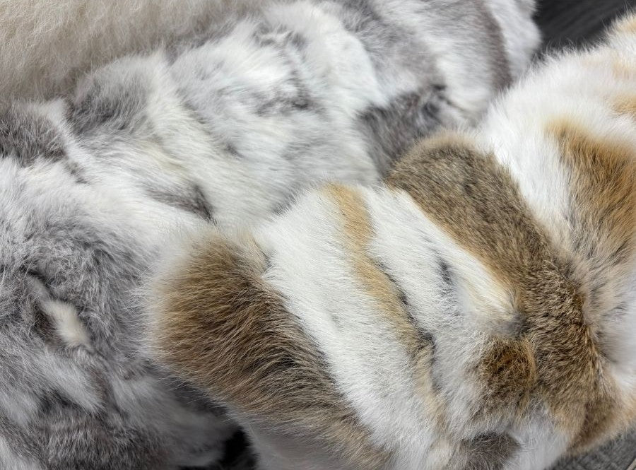 Close-up of natural brown, grey and white rabbit fur showing soft textured pattern
