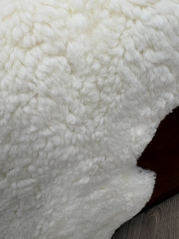 Detailed view of genuine natural white shearling with dense wool and a soft, plush finish.