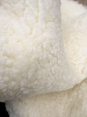 Detailed view of genuine natural white shearling with soft, plush wool and a luxurious finish.
