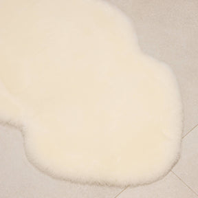 Natural white sheepskin baby rug laid flat showing natural shape and dense wool texture