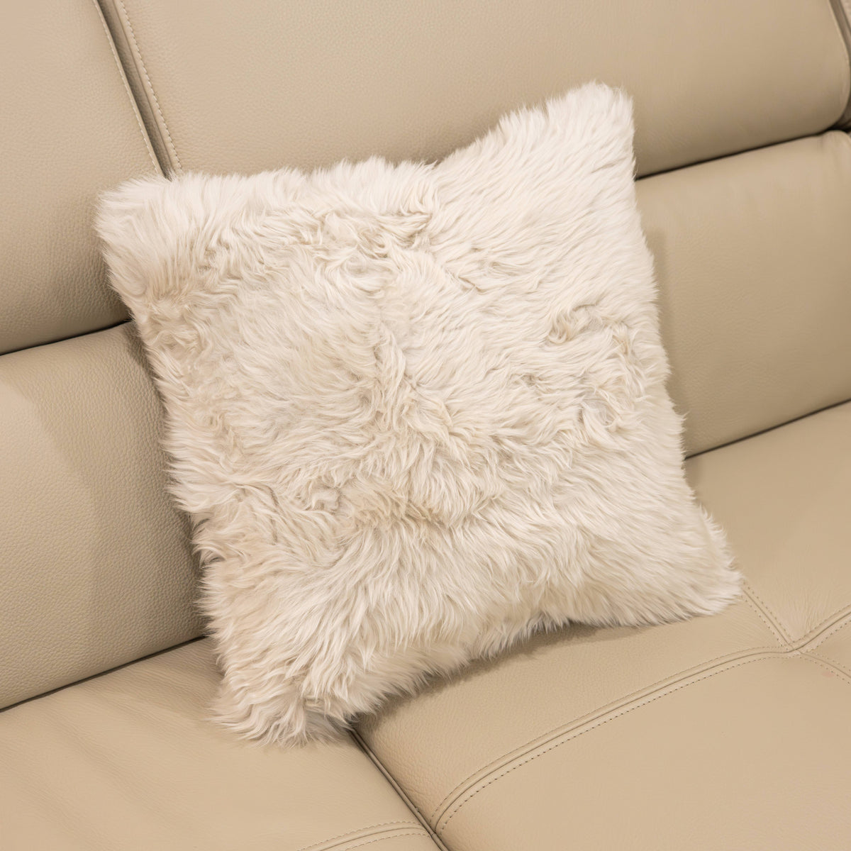 New Zealand sheepskin cushion in linen with soft long wool texture displayed on a beige sofa
