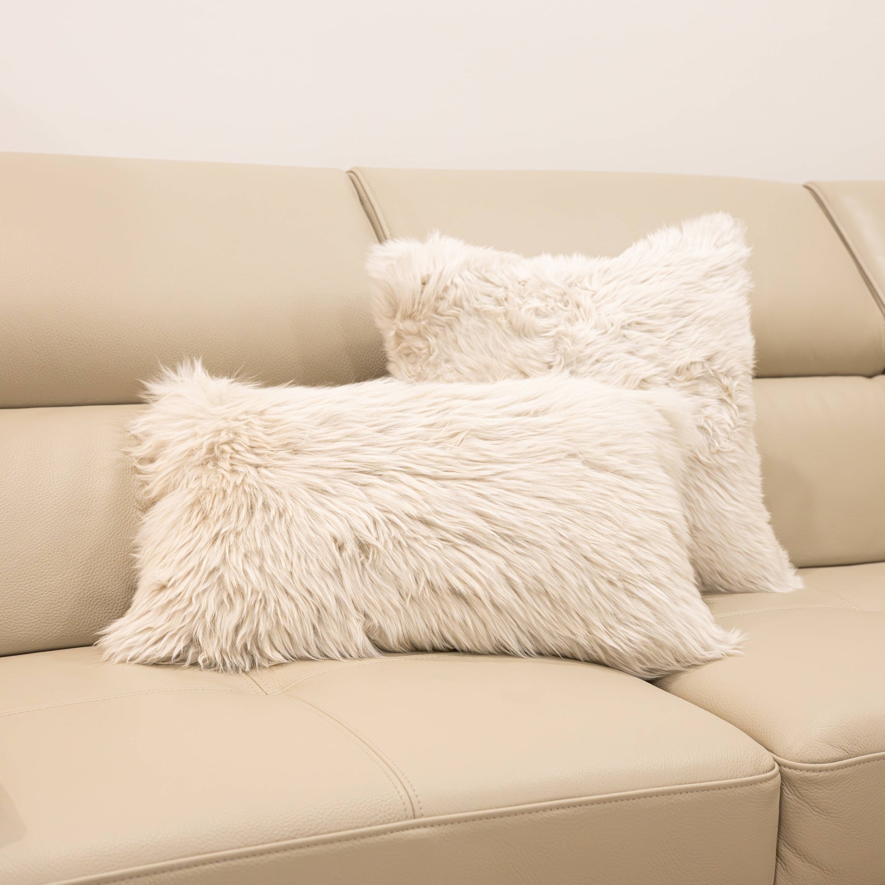 New Zealand sheepskin cushions in linen including square and lumbar styles displayed together on a beige sofa
