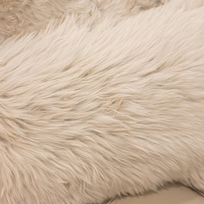 Close-up texture of New Zealand sheepskin cushion in linen showing soft long wool fibres and natural variation