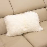 New Zealand sheepskin lumbar cushion in natural white with soft long wool texture displayed on a beige sofa
