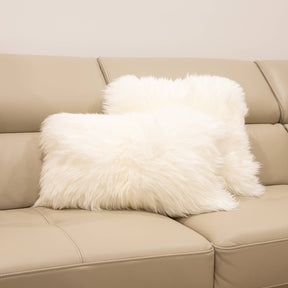 Two New Zealand sheepskin cushions in natural white styled together on a beige sofa